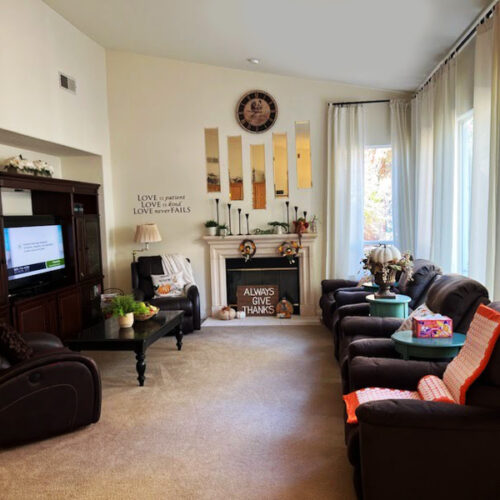 Senior living common area in Folsom with cozy fireplace and seating arrangement.
